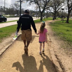 Blog - Man Holding the Hand of a Young Girl as They Walk Down the Sidewalk on a Nice Day