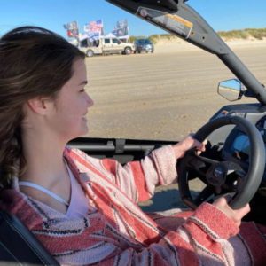 Blog - Woman Smiling While Driving on the Beach on a Beautiful Day