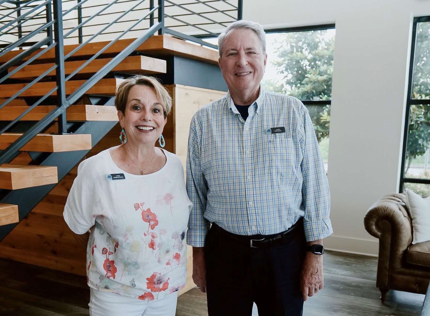 Two adults standing in a lobby. They are about to discuss Growing Gratitude with employees of Highpoint Insurance Group
