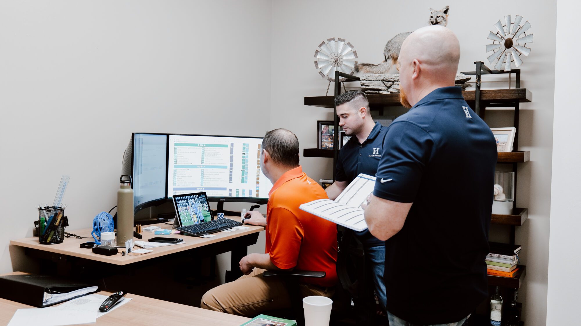 3 men looking at a computer screen in an office